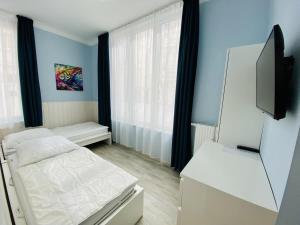 um pequeno quarto com uma cama e uma televisão em Berringer Lachs em Warnemünde
