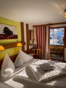 a hotel room with a bed with pillows on it at Hotel Tenne in Sankt Anton am Arlberg