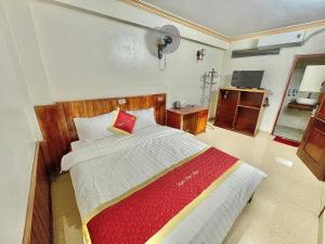 a bedroom with a bed with a red and white blanket at Happy Hotel & Spa in Sapa