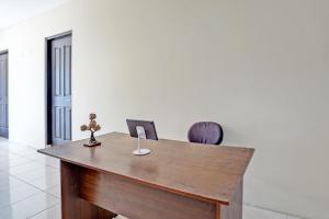 an office with a wooden desk and a chair at OYO Life 93111 Garden Homestay 2 Merlion in Lontar