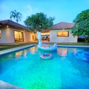 una piscina con un tobogán inflable y una casa en Sunny2 Villa Pattaya, en Ban Huai Yai