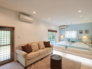 a living room with a couch and a bed at ADAN RESORT 風 - Fu - in Bise