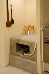 a kitchen with a stone fireplace in a room at かまどと壺湯之宿 大阪ミナミ–Residence inn Kamado and Tsuboyu- in Osaka