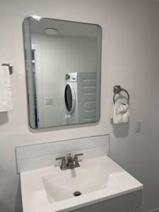 a bathroom sink with a mirror and a microwave at Stylish 2 Bedroom suite in SW Edmonton close to Windermere and Edmonton International Airport in Edmonton