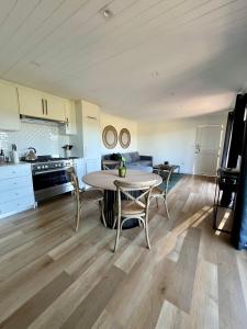 uma cozinha e sala de jantar com mesa e cadeiras em The Milkwoods Luxury Living em Mossel Bay