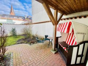 a patio with a table and chairs under a gazebo at Haus Juliane, Sandstrand in Warnemünde