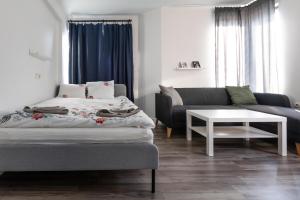 - une chambre avec un lit, un canapé et une table dans l'établissement Refurbished studios, mountain view balconies, minutes from gondola, à Bansko