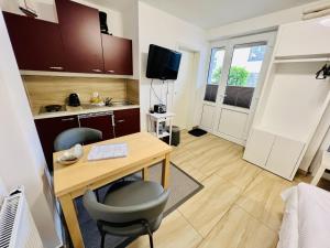 a small room with a desk and a kitchen at Haus Juliane, Sandstrand in Warnemünde