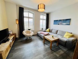 ein Wohnzimmer mit einem Sofa und einem Tisch in der Unterkunft Haus Jantzen/Arkona in Warnemünde