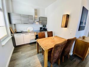 eine Küche mit einem hölzernen Esstisch und Stühlen in der Unterkunft Haus Jantzen/Arkona in Warnemünde