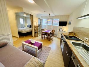 Una cocina y una sala de estar con un sofá y una mesa. en Haus Juliane, Lichtblick, en Warnemünde