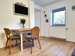 a dining room with a table and chairs and a television at Sweet Stay Roznik Apartment in Ljubljana