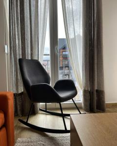 a black chair sitting in front of a window at Stasa_cozy_nest in Kolašin