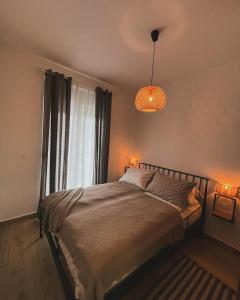 a bedroom with a bed with a window and a lamp at Stasa_cozy_nest in Kolašin