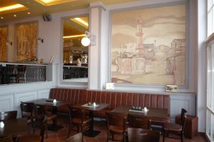 una sala da pranzo con tavoli e un dipinto sul muro di Doppelzimmer Lunch, direkt am Alten Strom a Warnemünde