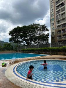 dwoje dzieci bawi się w basenie w obiekcie SN HOMESTAY (BATU CAVES) w mieście Batu Caves