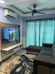 a living room with a couch and a flat screen tv at SN HOMESTAY (BATU CAVES) in Batu Caves