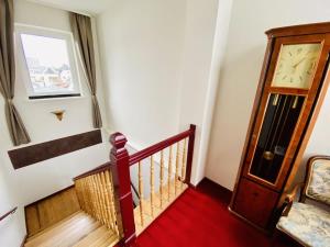 un escalier avec une horloge sur le mur dans l'établissement Doppelzimmer Cocktail, direkt am Alten Strom, à Warnemünde