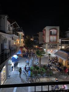 a view of a city at night with people walking around at Atelie home experience serres in Serres