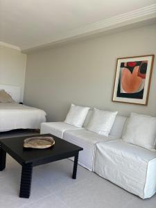 a living room with a white couch and a coffee table at Newly Renovated Sunny Studio - 5min Walk to Beach in Sydney