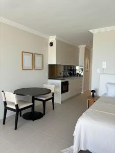 a room with a table and chairs and a kitchen at Newly Renovated Sunny Studio - 5min Walk to Beach in Sydney