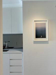a picture hanging on a wall in a kitchen at Newly Renovated Sunny Studio - 5min Walk to Beach in Sydney