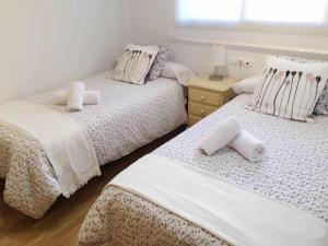 ein Schlafzimmer mit 2 Betten und Handtüchern darauf in der Unterkunft Apartamento en Av de Francia y CArtes y Ciencias in Valencia
