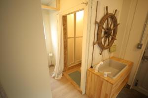 a bathroom with a mirror and a wheel on the wall at Seaside Harbor Odawara シーサイド ハーバー 小田原 in Odawara