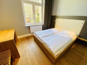 um quarto com uma cama e uma janela em Kapitän Karsten em Warnemünde