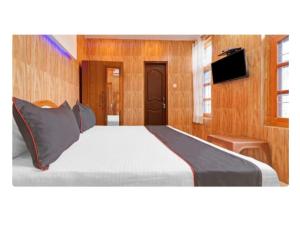 een slaapkamer met een groot bed en een televisie bij Regency Hotel and Restaurant, Sarkaghat, HP 