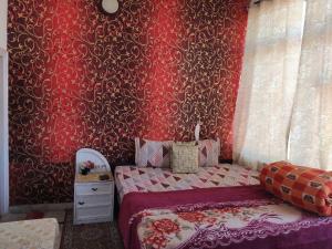1 dormitorio con cama y pared roja en Solan Regency, en Solan