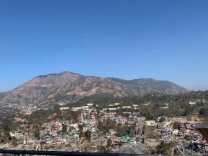 a view of a city with mountains in the background at Solan Regency in Solan