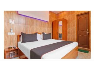 een slaapkamer met een groot wit bed en houten wanden bij Regency Hotel and Restaurant, Sarkaghat, HP 