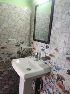 y baño con lavabo y espejo. en Solan Regency, en Solan