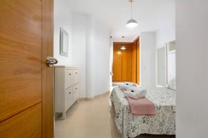 una piccola camera con due letti e una porta di Puerto Playa 2 a Puerto del Rosario