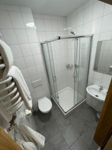 a bathroom with a shower and a toilet and a sink at Motel Pieprzyk in Kołobrzeg