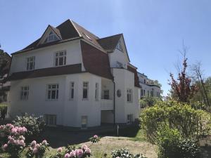 uma casa branca com um telhado castanho em Kaethchen em Warnemünde