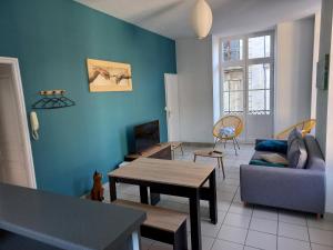 ein Wohnzimmer mit einem Sofa und einem Tisch in der Unterkunft immeuble entier ✰ coeur de ville ✰ terrasse balcon in Segré