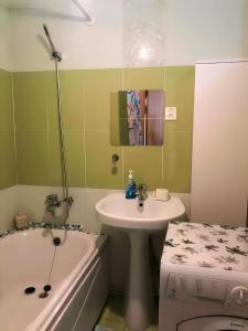 a bathroom with a sink and a bath tub next to a toilet at VERY central location near State department store in Ulaanbaatar