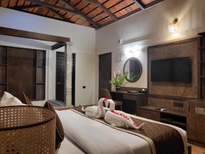 Una habitación de hotel con una cama con dos cisnes. en Nirvana Club Resort and Spa, en Bangalore