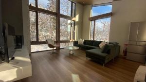 a living room with a couch and a chair at Chalet Infinity by The Hakuba Collection in Hakuba