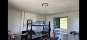 Zimmer mit 2 Etagenbetten und einem Fenster in der Unterkunft DOC AZENITH PRESIDENTIAL SUITE in Pagadian