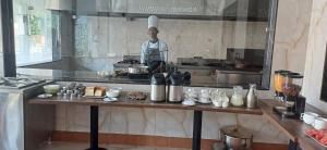 un hombre de pie en una cocina preparando comida en Nirvana Club Resort and Spa, en Bangalore