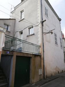 ein Gebäude mit einer grünen Tür und einem Balkon in der Unterkunft immeuble entier ✰ coeur de ville ✰ terrasse balcon in Segré
