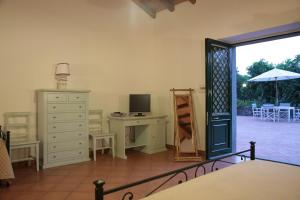 a room with a dresser and a desk with a computer at Lumia in Riposto