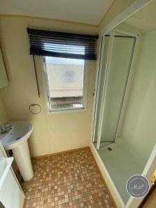 a bathroom with a shower and a sink at Happy Days - Beachfields 370 in Chapel Saint Leonards