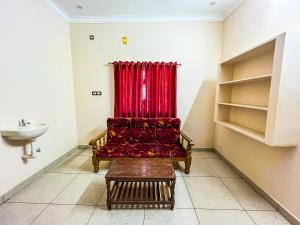 ein Wohnzimmer mit einem roten Sofa und einem Waschbecken in der Unterkunft Royal Castle Residency in Puducherry