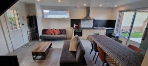 eine Küche und ein Wohnzimmer mit einem Sofa und einem Tisch in der Unterkunft Aux Passagers de la Baie 3 in Le Crotoy