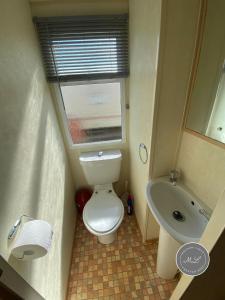 a small bathroom with a toilet and a sink at Happy Days - Beachfields 370 in Chapel Saint Leonards