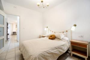 een witte slaapkamer met een bed en een tafel bij Casa Olga in Rota